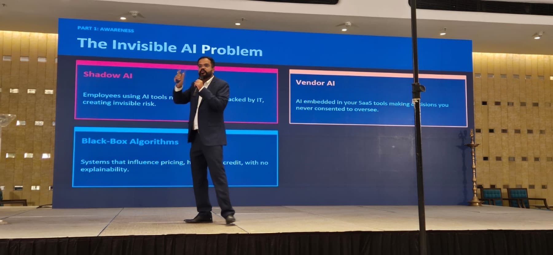 Amit Kumar Soni on stage in front of a slide titled The Invisible AI Problem.