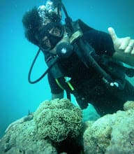 Amit scuba diving near a coral reef.