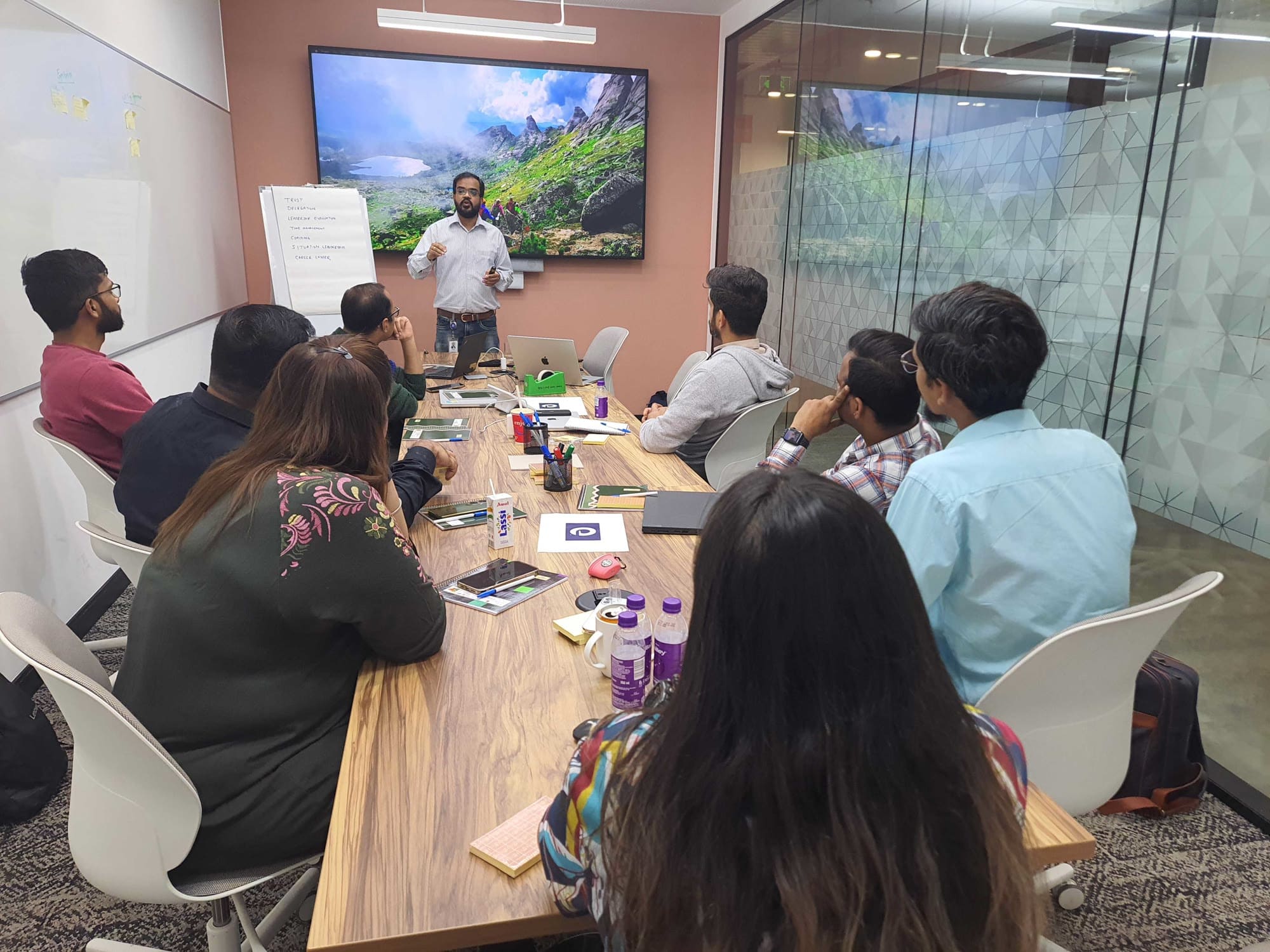 Amit facilitating a workshop with an engaged group around a table.